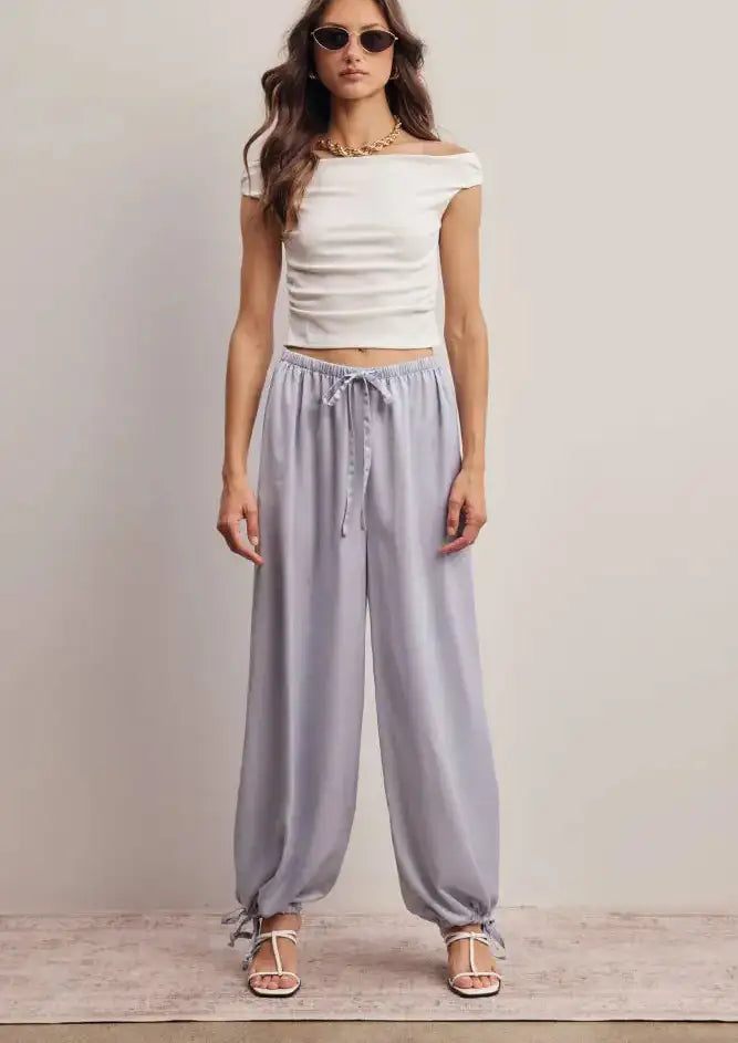 Light gray satin harem pants with drawstring waist and ankle ties.